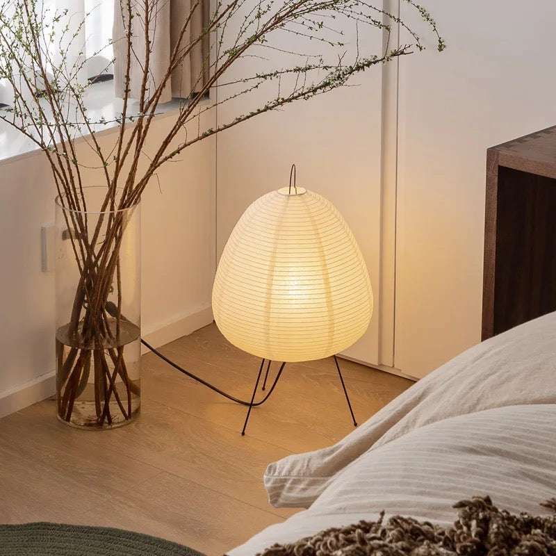 Handmade traditional Japanese rice paper lamp with iron tripod, soft white lighting in cozy room corner
