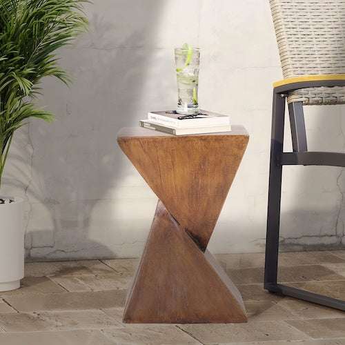 lightweight concrete narrow side table with geometric design and natural wood finish next to chair and plant