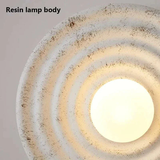 Modern round wall light fixture with resin lamp body and frosted glass, ideal for chic home illumination