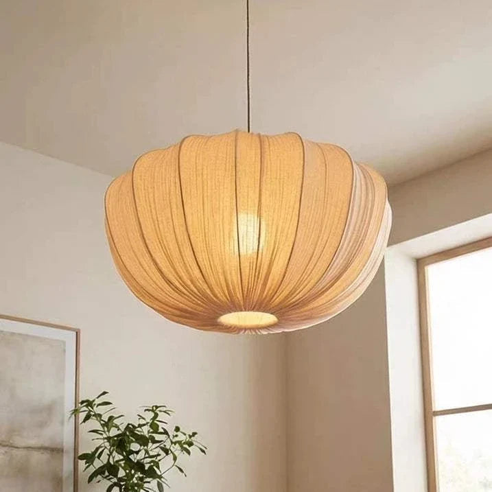 Wabi-Sabi fabric pendant light with soft cream shade, mid-century Japanese design, hanging by thin wire cord in cozy dining room setting