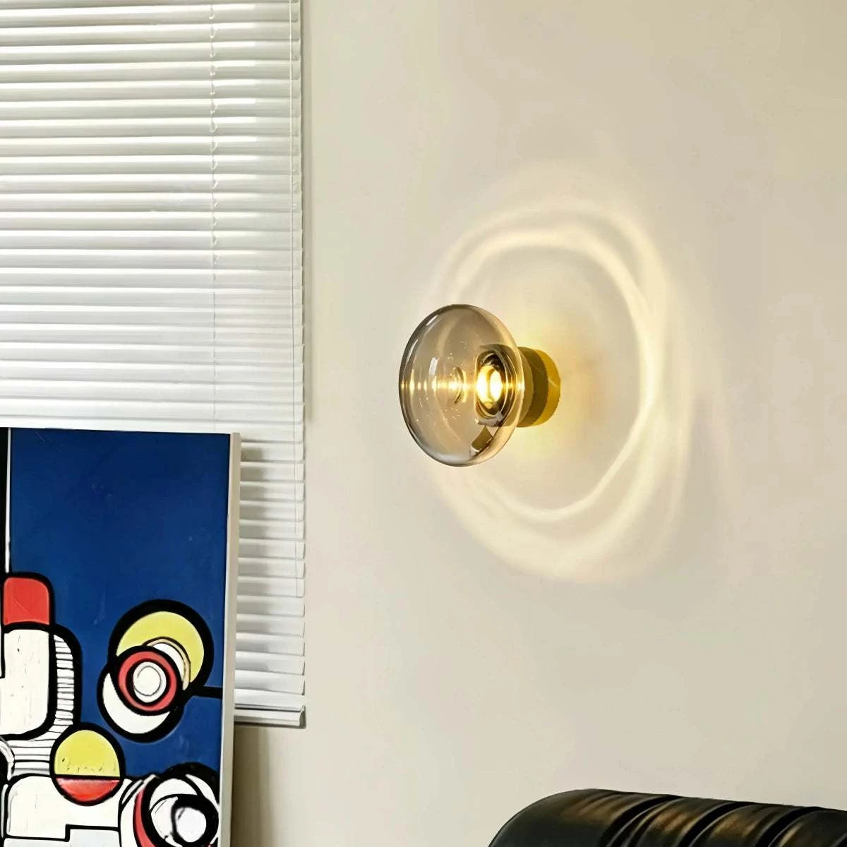 Bauhaus glass wall sconce with hand-blown gradient glass and LED projection light creating circular patterns on wall in modern interior.
