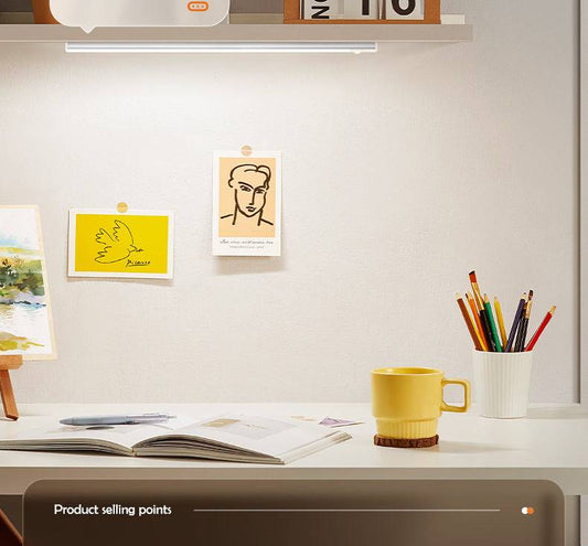 Motion sensor night light illuminating a modern desk workspace with art prints and stationery.