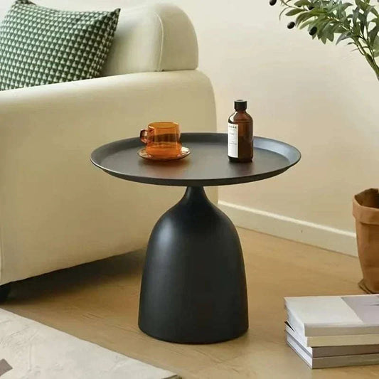 modern black metal side table with round top and sturdy base in living room setting