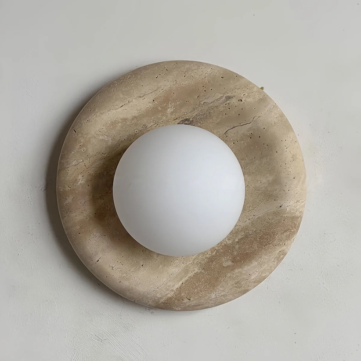 Natural travertine marble wall sconce with LED light in rustic wabi-sabi design for bedroom and hallway ambiance