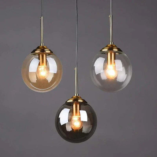 Modern hanging lamp set featuring three polished steel pendant lights with clear, amber, and smoke grey glass shades and LED bulbs