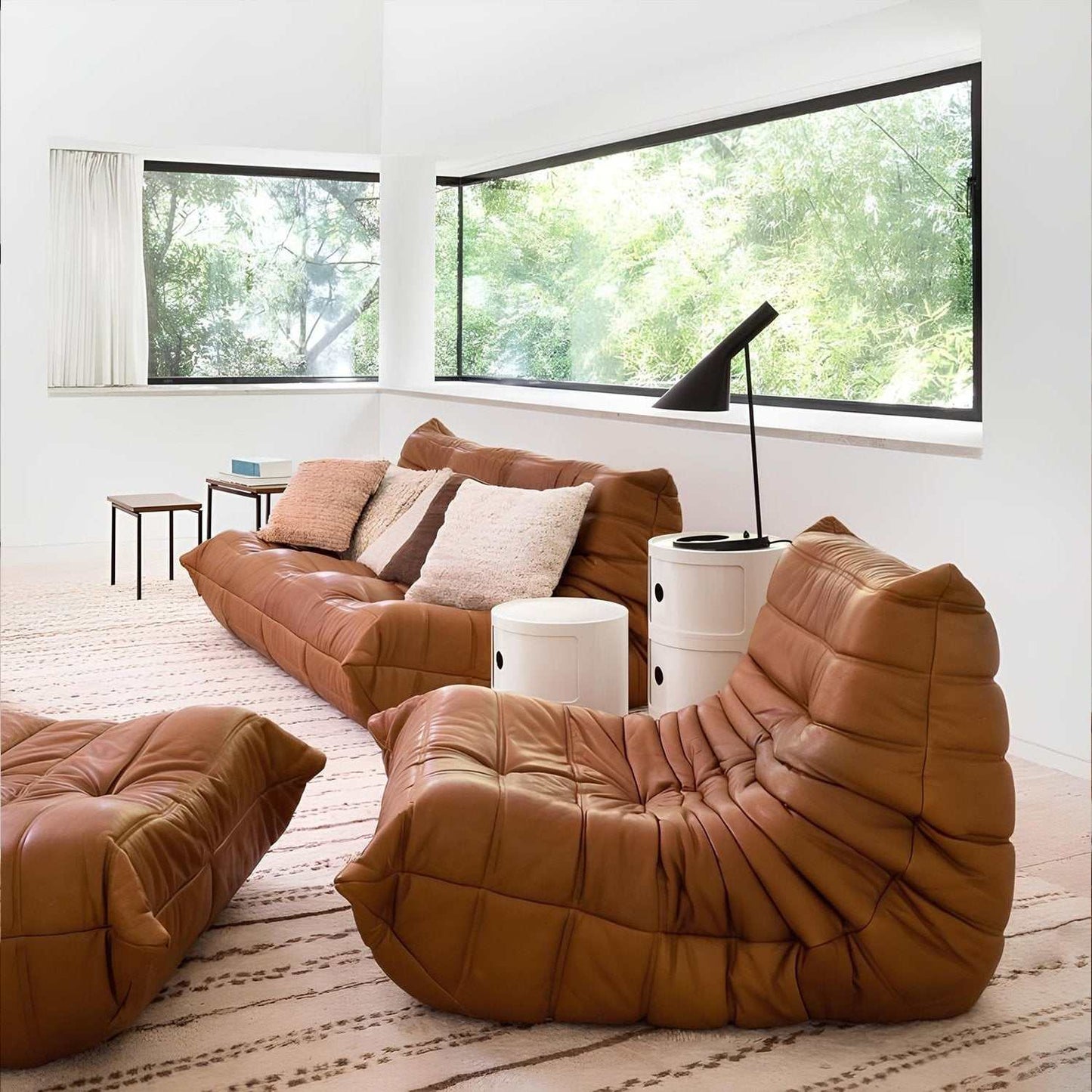 brown leather armchair and ottoman in modern living room with large windows and white walls