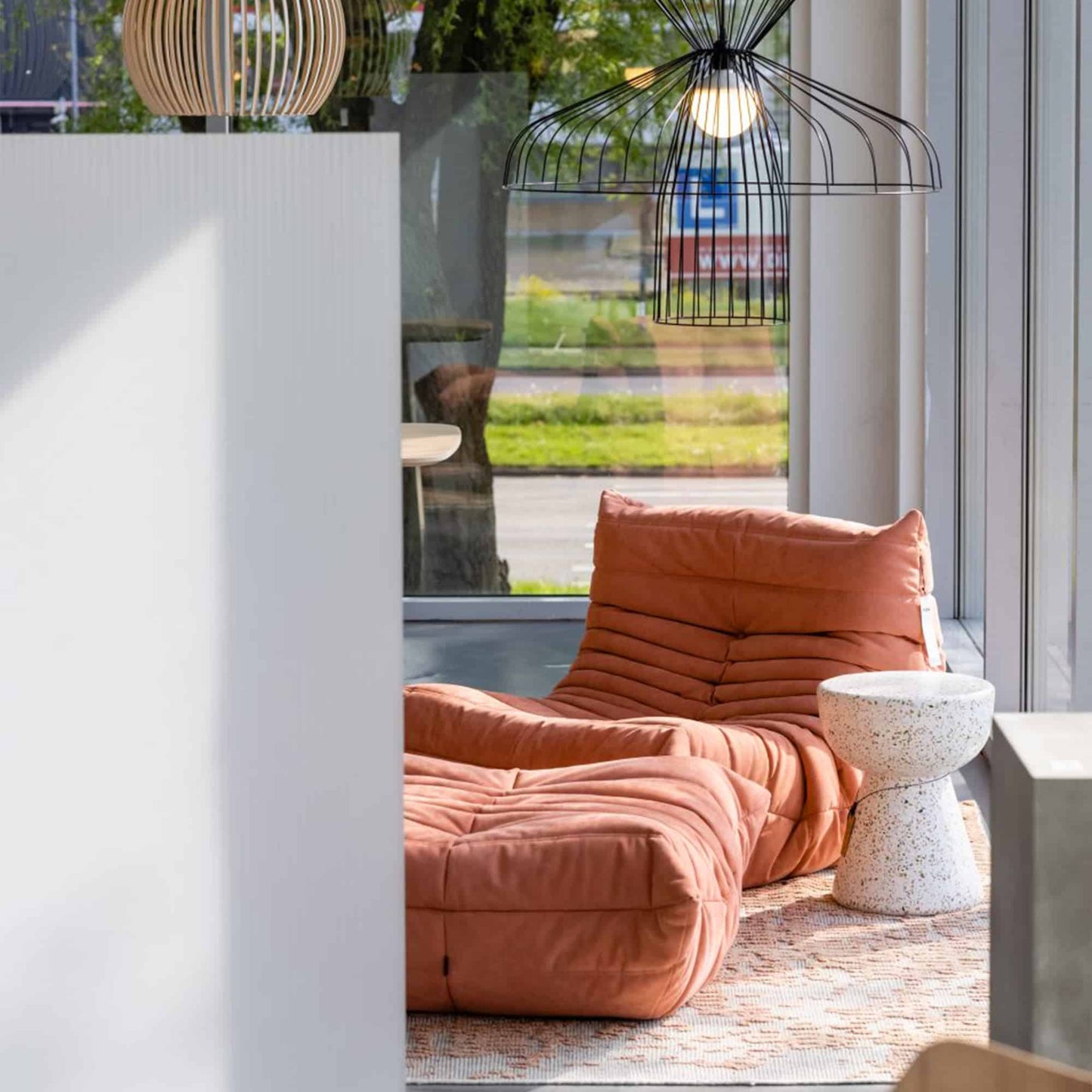 Modern orange suede armchair and ottoman set in cozy living room corner near window