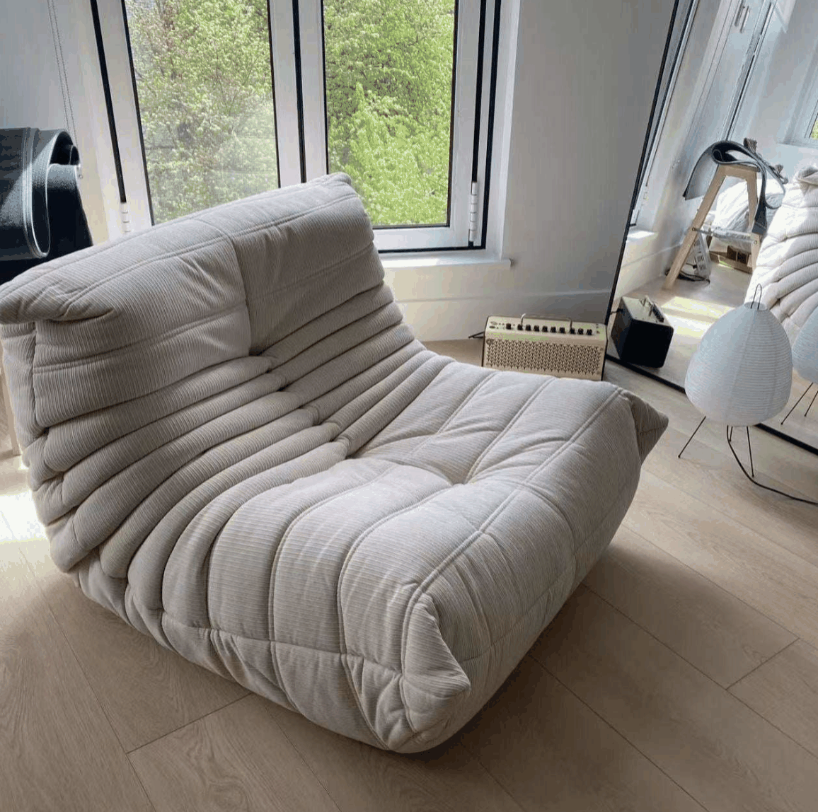 Corduroy Elegance Caterpillar armchair in light beige with soft textured fabric and modern minimalist design in bright living room.