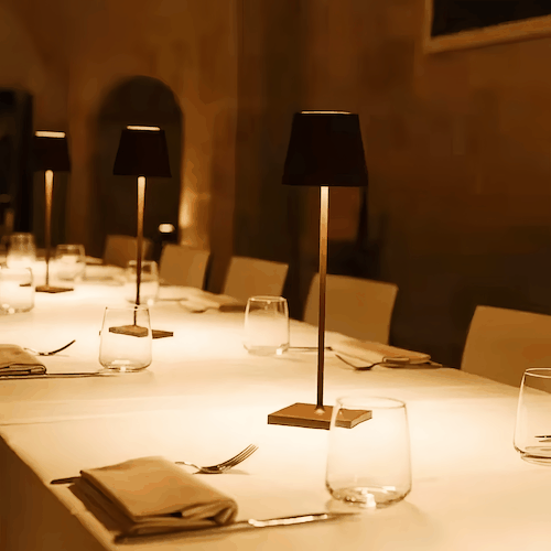 Cordless rechargeable table lamp with adjustable brightness and modern design lighting a dining table
