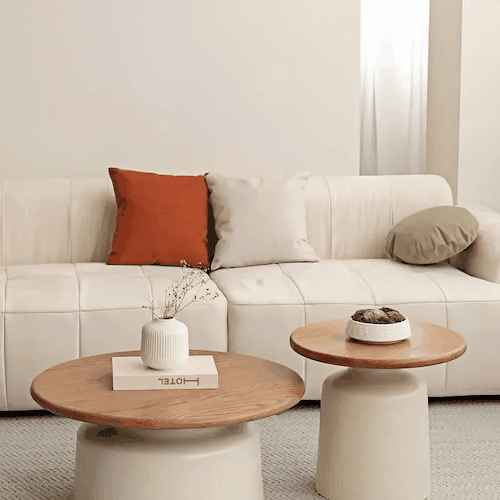 Minimalist round coffee table with oak wood top and off-white base in modern living room setting