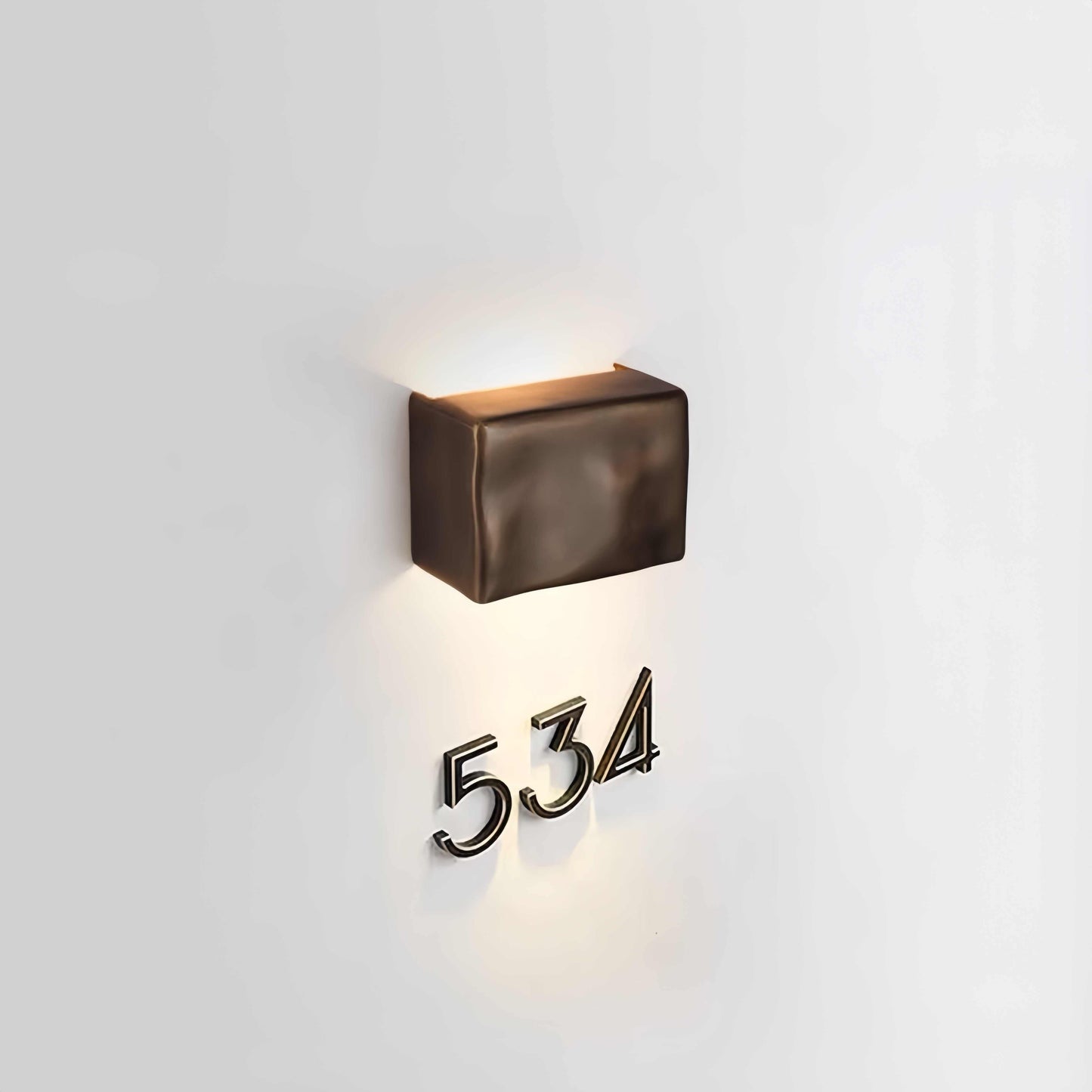 Scape Wall Light bronze waterproof outdoor sconce illuminating house numbers on white wall