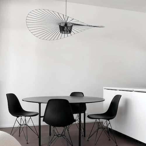 Modern black Straw Hat LED Ceiling Light hanging above black round dining table with four black chairs in minimalist white room