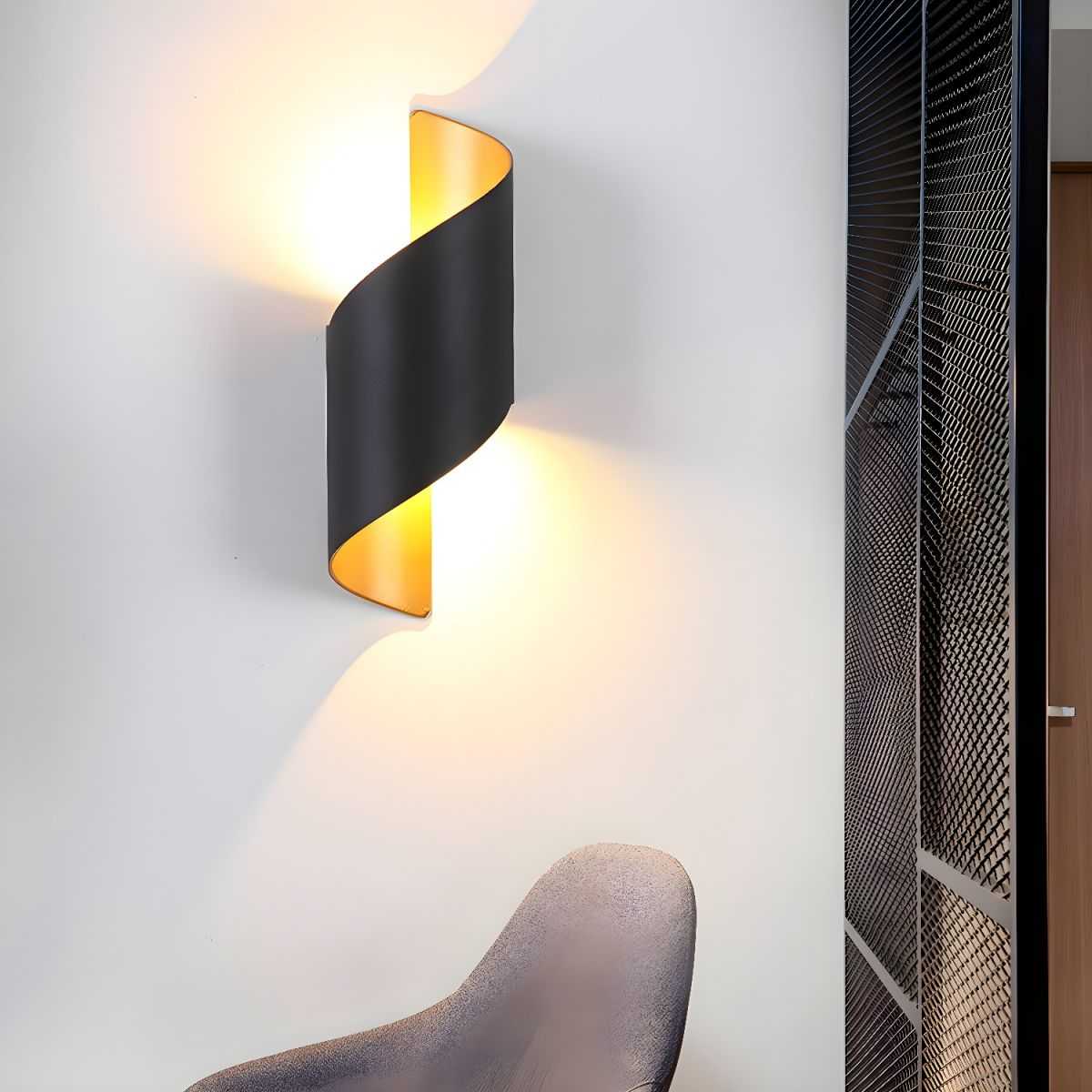 Postmodern unique sconce light with black metal curved design and warm ambient lighting on wall above chair