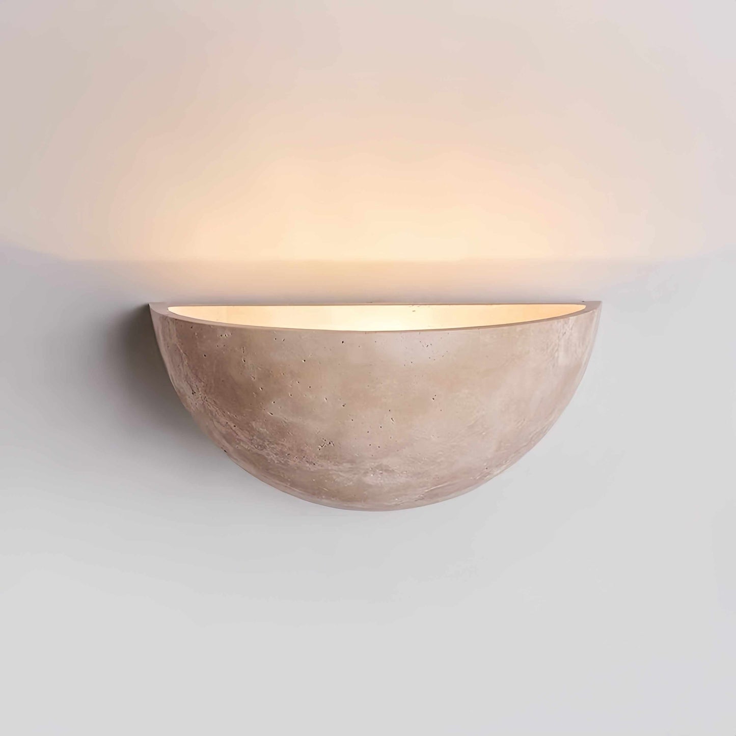 Vintage Wabi-Sabi style wall sconce made of natural off-white travertine casting soft warm light