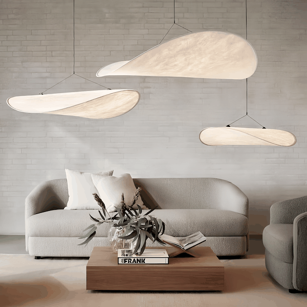 Contemporary living room pendant light with soft warm glow and elegant Dupont paper design above sofa and wooden coffee table
