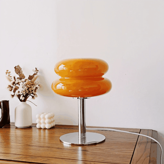Macaron LED Table Lamp with orange stained glass shade and silver base on wooden table