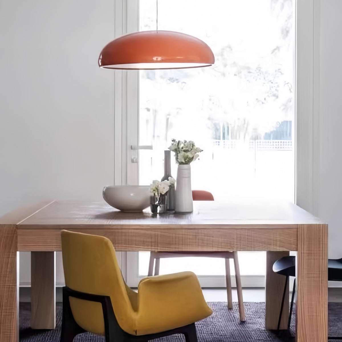 Modern minimalist red pendant light hanging in a stylish living room setting