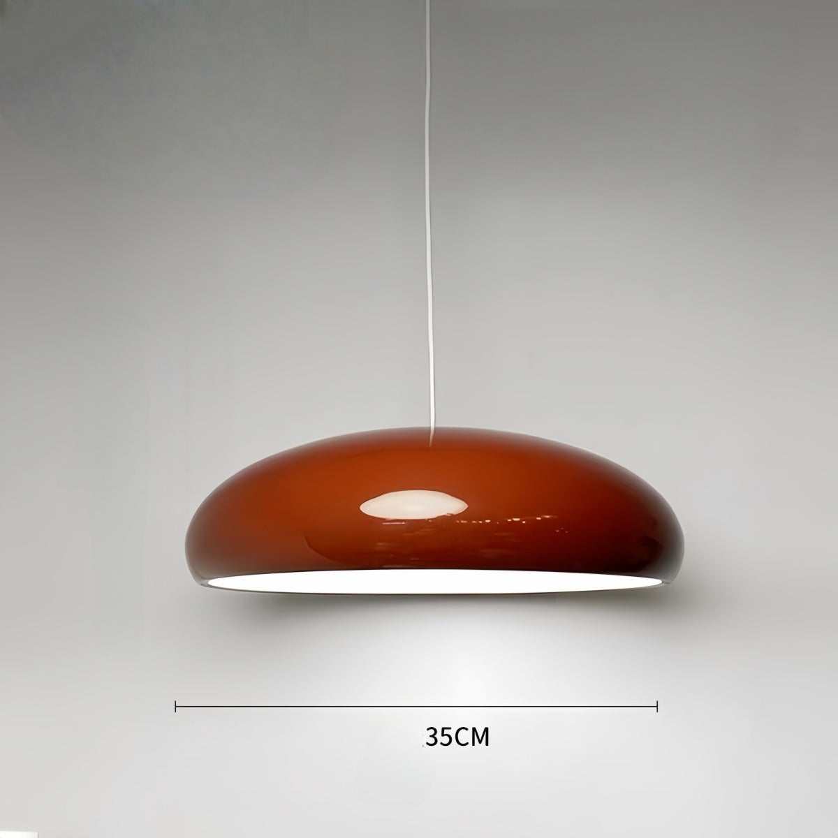 Modern minimalist red pendant light hanging in a stylish living room interior