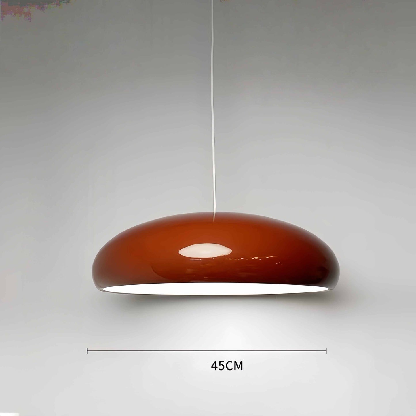 Modern minimalist red pendant light hanging in a stylish living room.