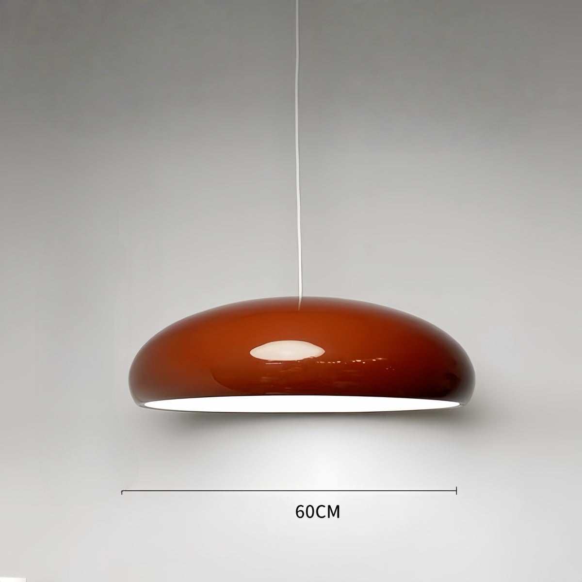 Modern minimalist red pendant light hanging in a stylish living room interior