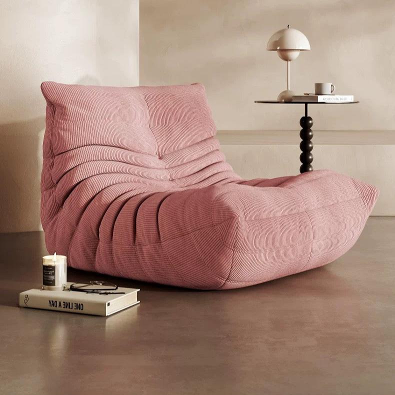 Cozy Togo Chair in soft pink corduroy for a stylish living room.
