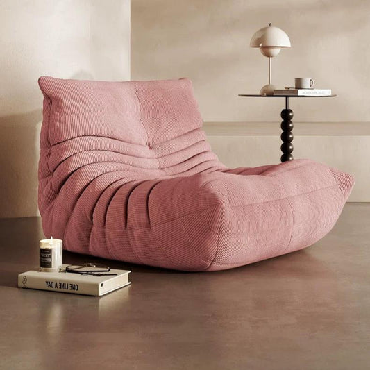 Cozy Togo Chair in soft pink corduroy for a stylish living room.