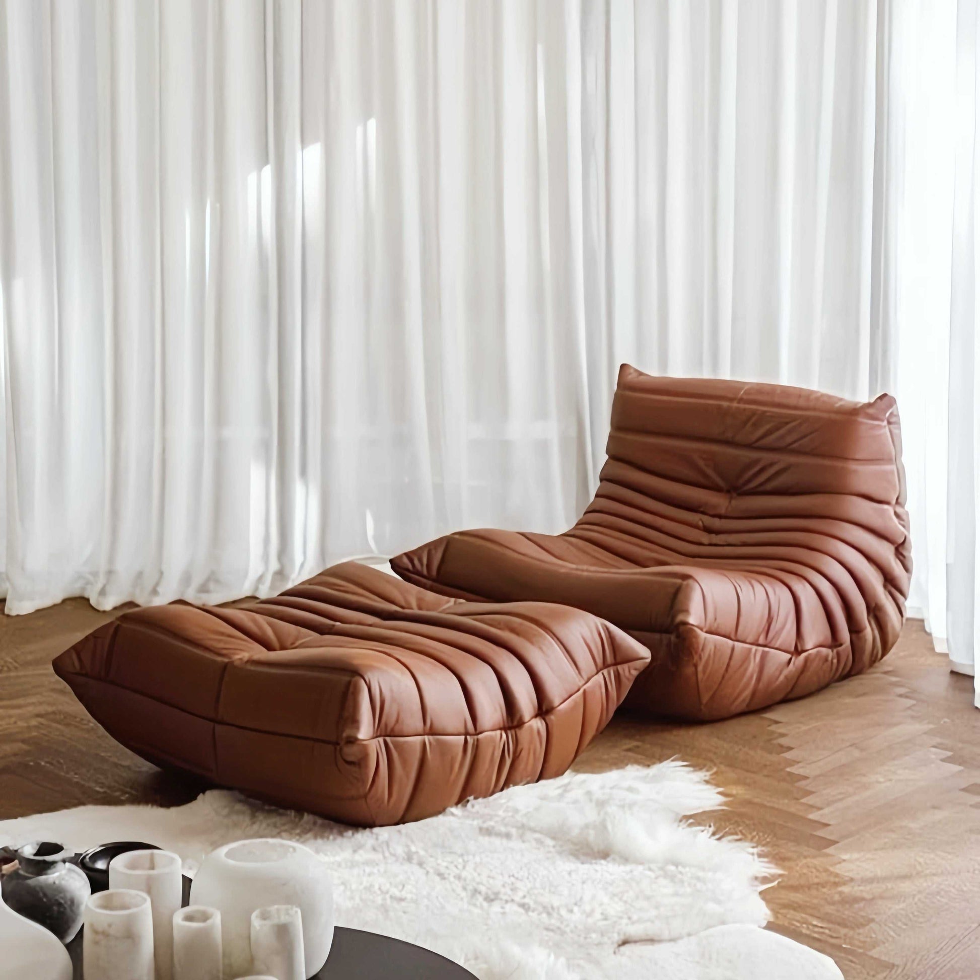 brown suede armchair and matching ottoman with modern contour design on wooden floor