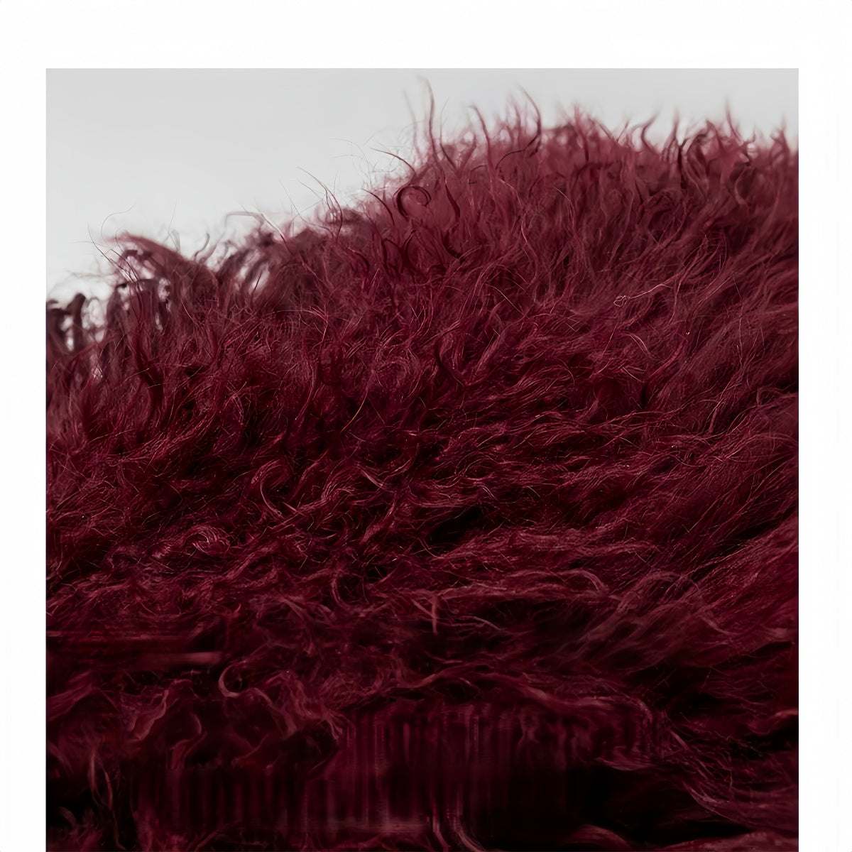 Modern minimalist burgundy lamb wool throw pillow with plush texture and full fluffy design for sofa or bed decor